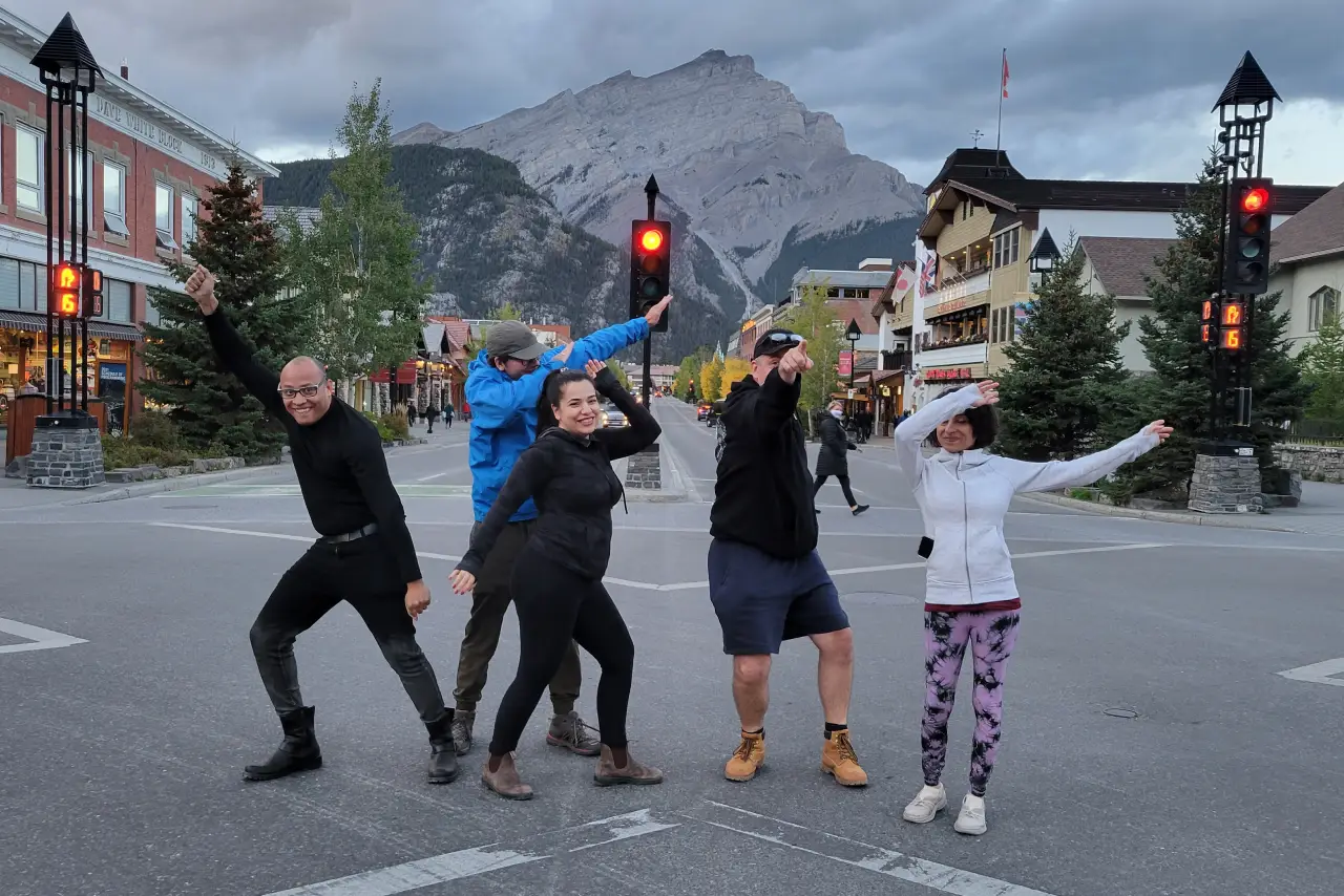 Group of people posing whimsically at a crosswalk in a mountain town.